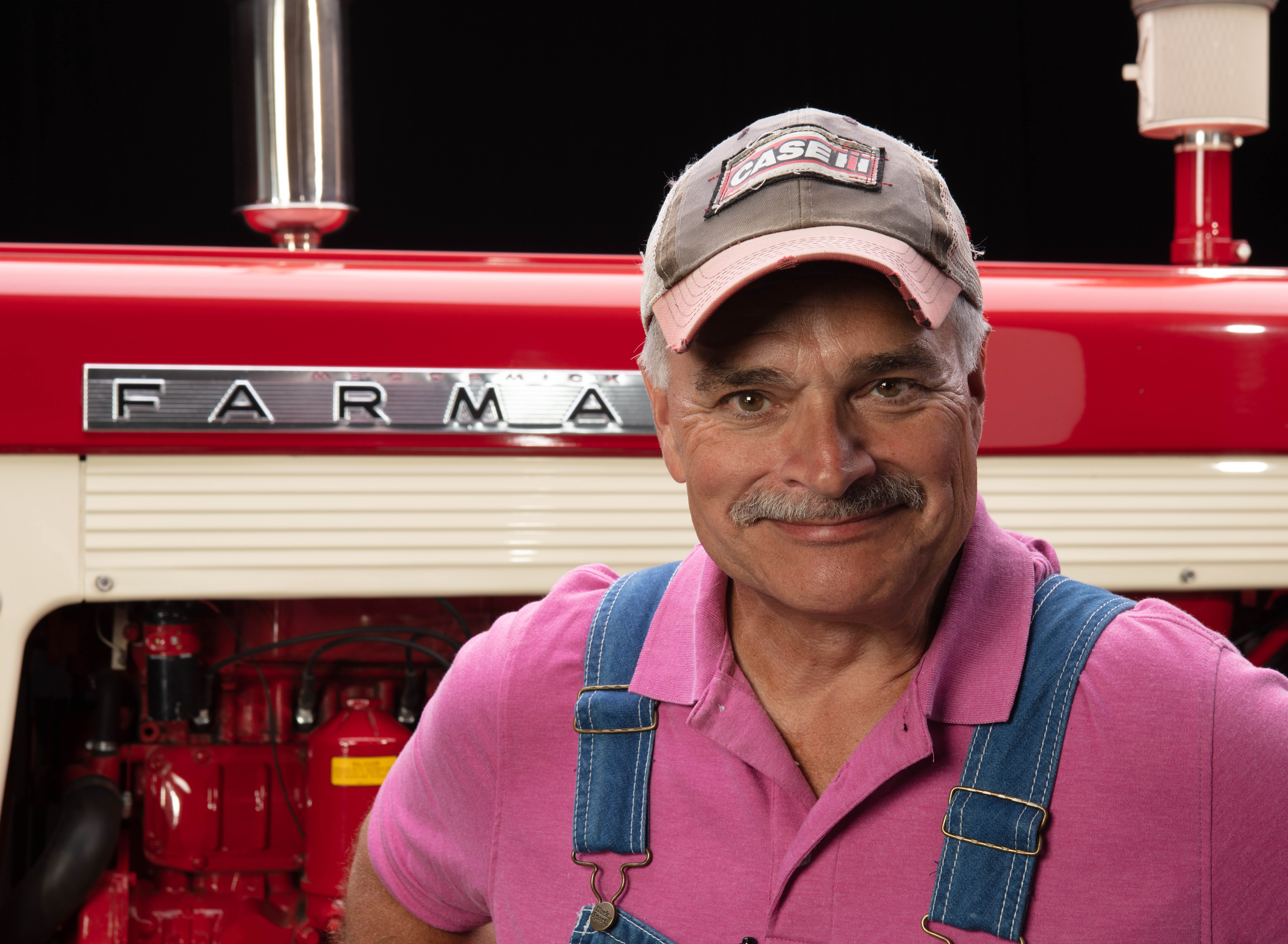 Max Armstrong in front of Farmall tractor